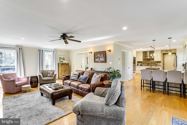 living room featuring light wood-style flooring, recessed lighting, and ornamental molding