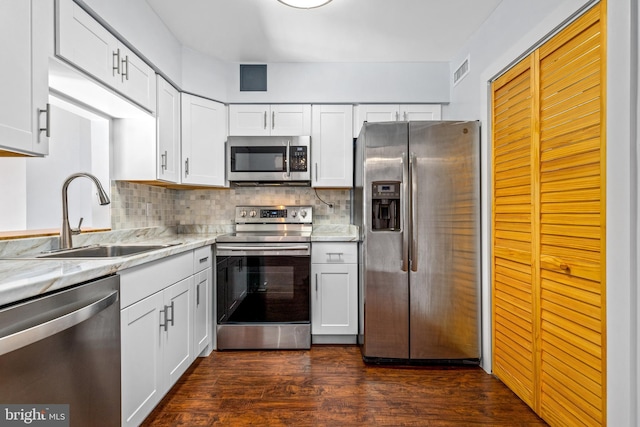 kitchen with a sink, dark wood-style flooring, backsplash, and stainless steel appliances