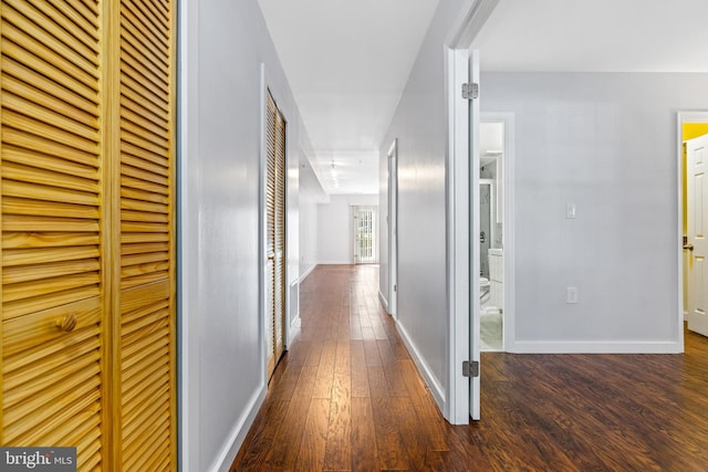 hallway featuring hardwood / wood-style floors and baseboards