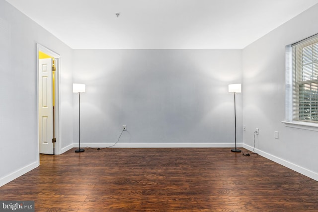 empty room with baseboards and wood finished floors