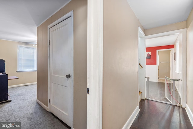 corridor with stairs, baseboards, and wood finished floors