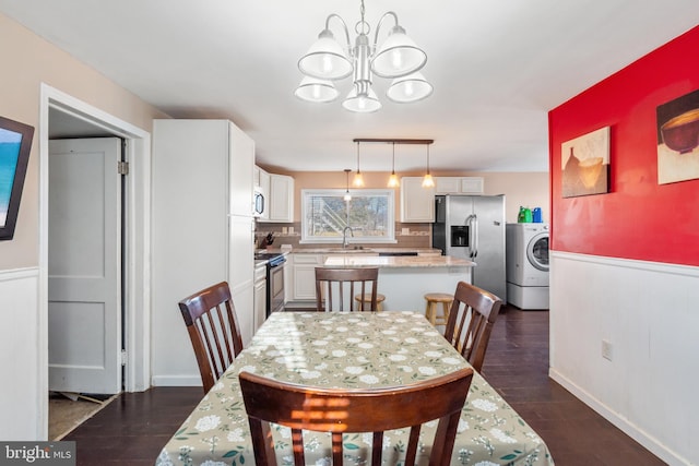 dining area with a notable chandelier, washer / dryer, and dark wood-style floors