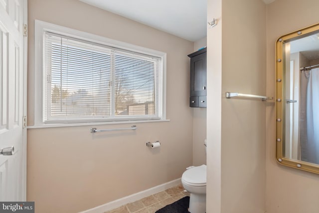 bathroom with tile patterned floors, toilet, and baseboards