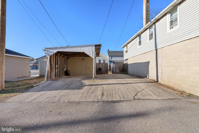 garage with a carport and fence