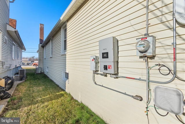 view of home's exterior with a lawn and central AC