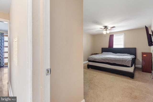 carpeted bedroom featuring baseboards and ceiling fan