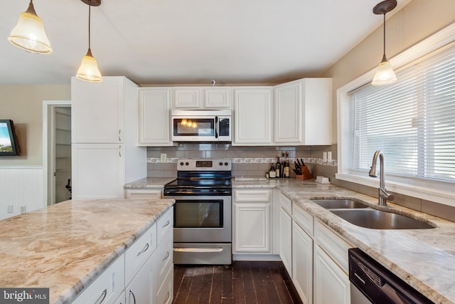 kitchen featuring dark wood finished floors, appliances with stainless steel finishes, white cabinetry, and a sink