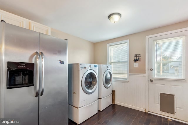 washroom with a wainscoted wall, independent washer and dryer, and dark wood-style flooring