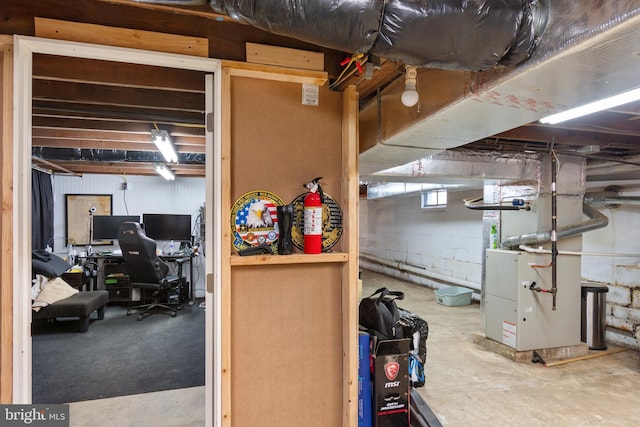 basement featuring heating unit and concrete block wall