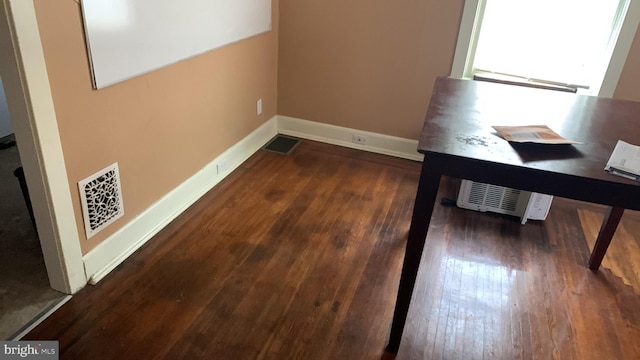 corridor with wood finished floors, visible vents, and baseboards