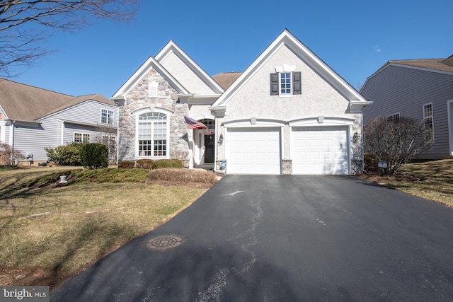 view of front of property with stone siding, a front lawn, and driveway