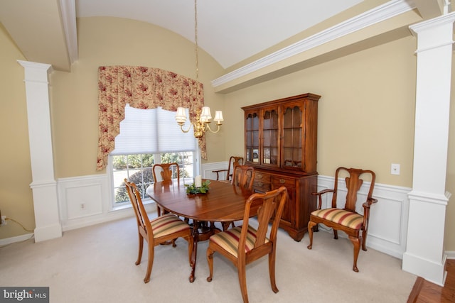 dining space with a chandelier, wainscoting, and ornate columns