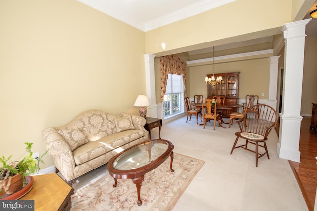 living area with crown molding, light carpet, decorative columns, and a chandelier