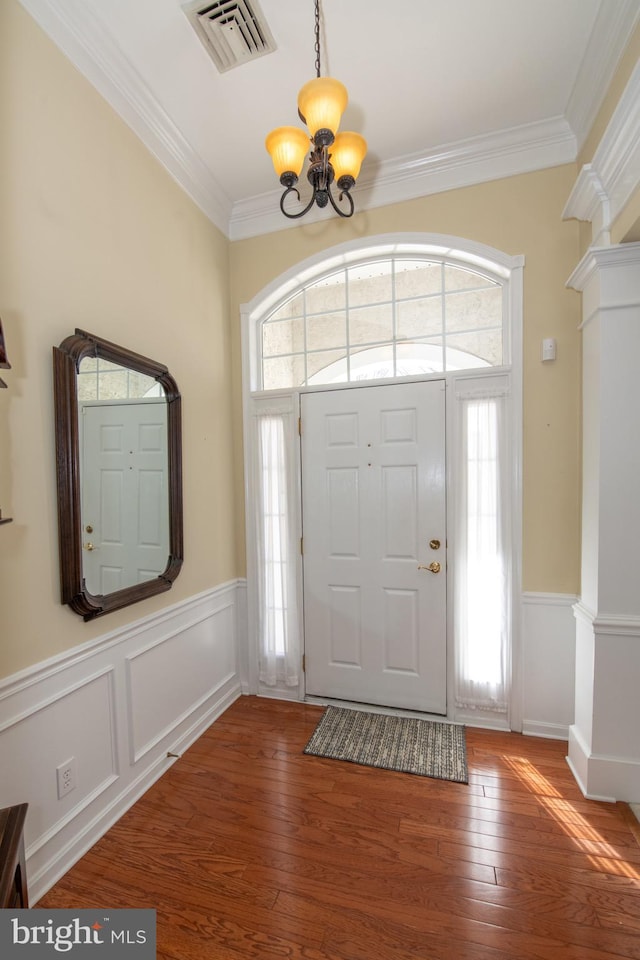 entryway featuring an inviting chandelier, hardwood / wood-style flooring, visible vents, and a wealth of natural light