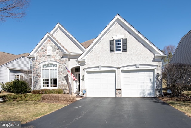 view of front of home with a garage, stone siding, and driveway