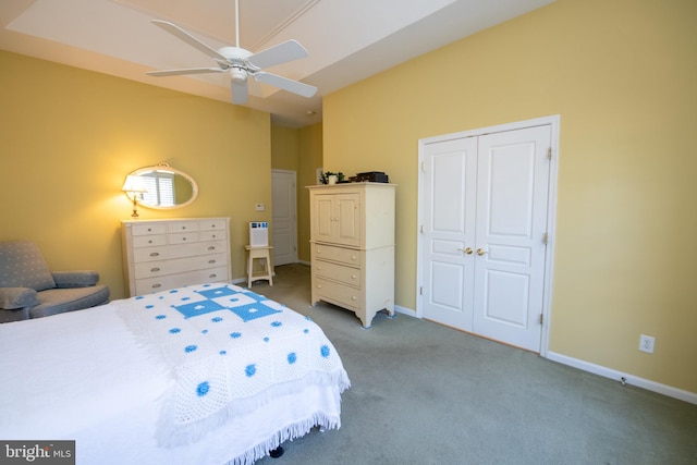 carpeted bedroom with a closet, baseboards, and a ceiling fan