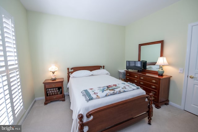 bedroom featuring light colored carpet and baseboards