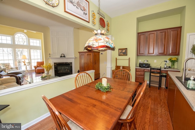 dining space with wood finished floors and a fireplace