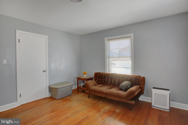 living area with light wood-style flooring, visible vents, and baseboards