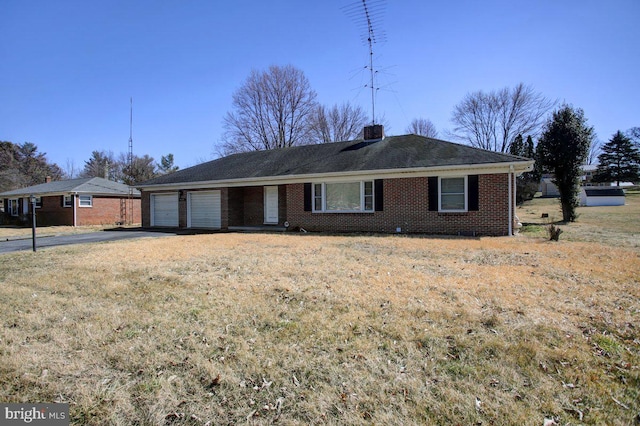 single story home featuring aphalt driveway, brick siding, a chimney, and an attached garage