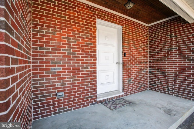 entrance to property featuring brick siding