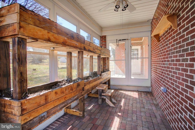 sunroom / solarium featuring a healthy amount of sunlight and ceiling fan