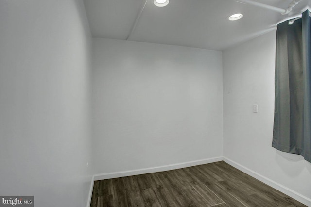 spare room featuring dark wood-style floors, recessed lighting, and baseboards