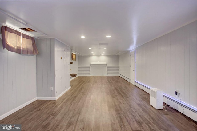 finished basement featuring a baseboard heating unit, recessed lighting, wood finished floors, and baseboards