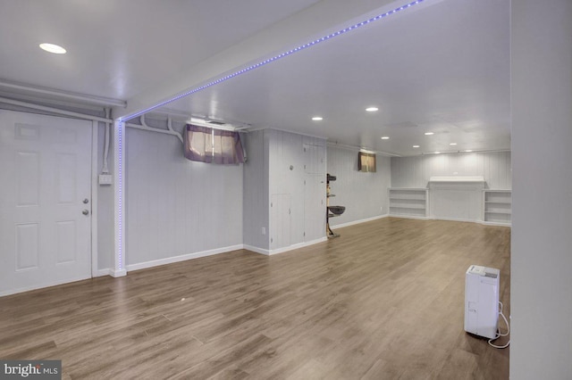 finished below grade area featuring recessed lighting, baseboards, and wood finished floors