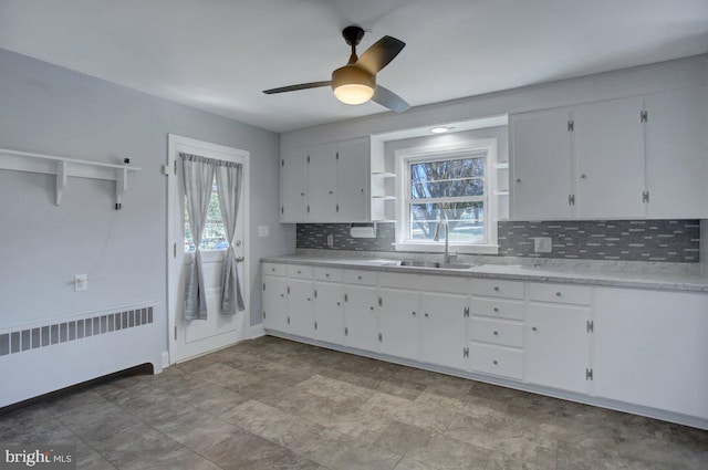 kitchen with a sink, white cabinets, radiator, and open shelves