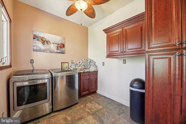 washroom featuring stone finish flooring, baseboards, cabinet space, a ceiling fan, and separate washer and dryer