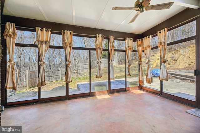 unfurnished sunroom featuring ceiling fan