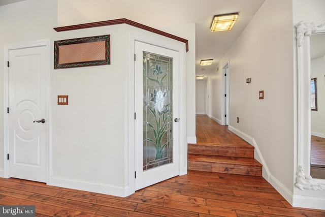 foyer entrance featuring hardwood / wood-style floors and baseboards