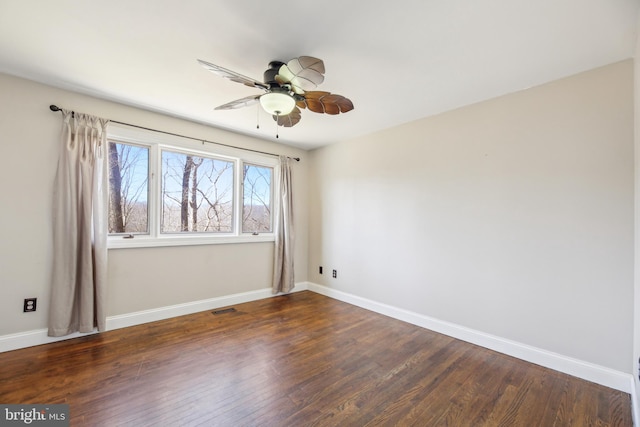 unfurnished room with dark wood finished floors, visible vents, ceiling fan, and baseboards