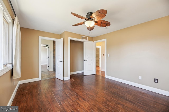 unfurnished bedroom with visible vents, a ceiling fan, baseboards, and hardwood / wood-style flooring