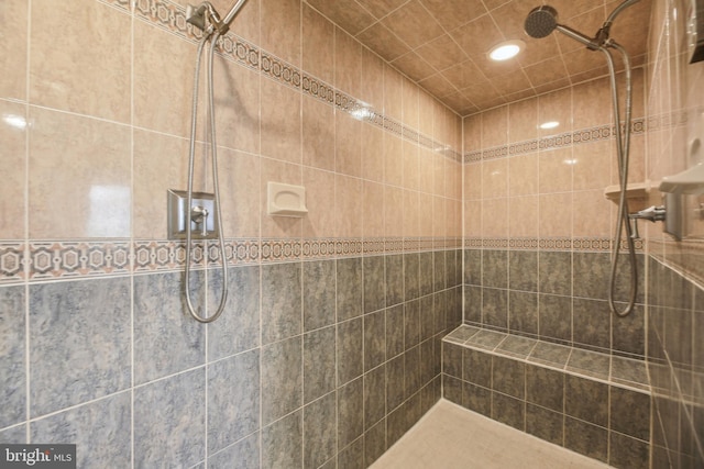 full bathroom featuring recessed lighting and tiled shower