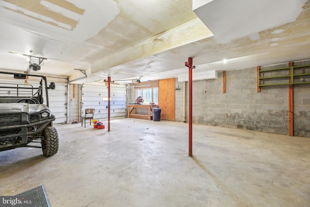 garage featuring concrete block wall and a garage door opener