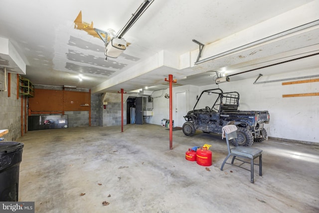 garage featuring a garage door opener and concrete block wall