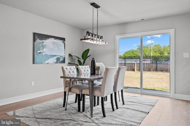 dining space featuring visible vents, baseboards, and wood finished floors