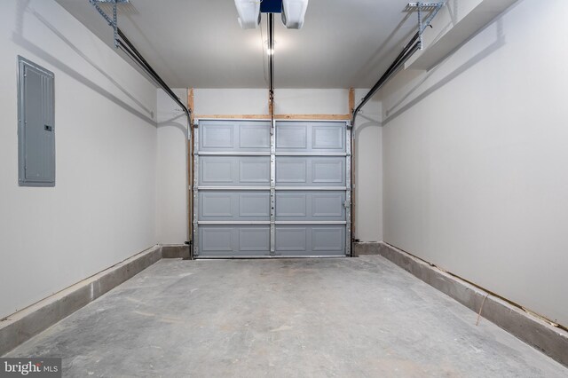 garage featuring electric panel and baseboards