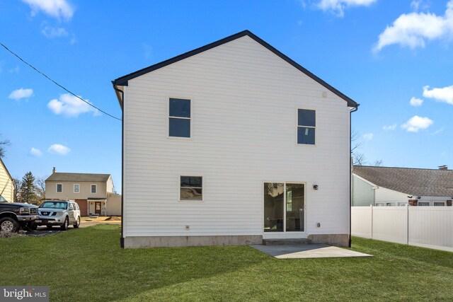 back of house featuring a patio, a lawn, and fence