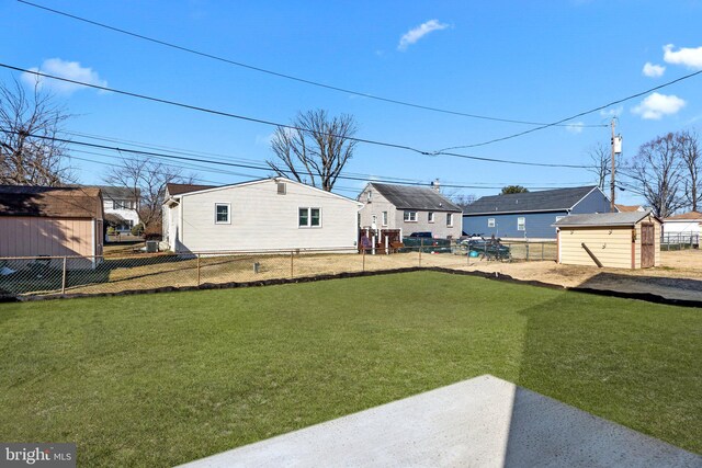 view of yard with a storage unit, an outbuilding, and a fenced backyard