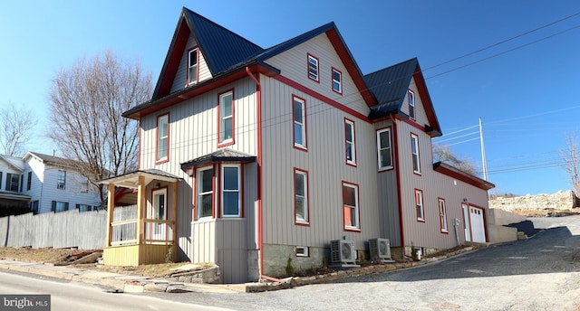 view of front facade featuring metal roof, fence, and ac unit