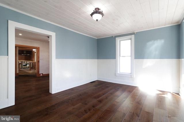 spare room with a wainscoted wall, wooden ceiling, dark wood-type flooring, and crown molding