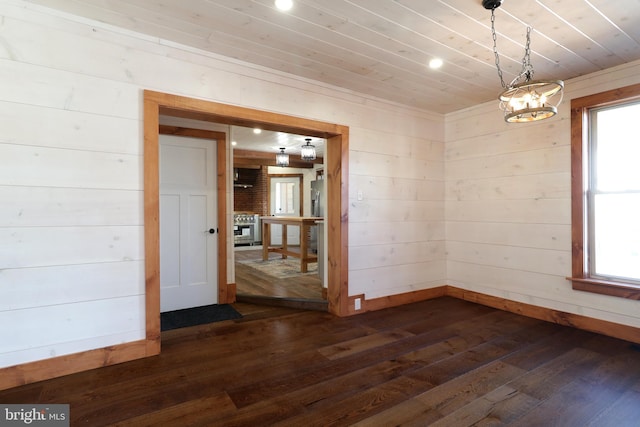 unfurnished dining area featuring wood ceiling, dark wood-style floors, and wood walls