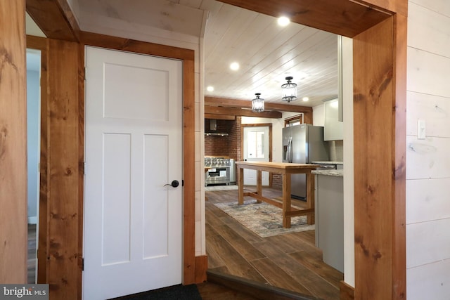 kitchen featuring recessed lighting, dark wood-style flooring, wood ceiling, white cabinetry, and stainless steel fridge