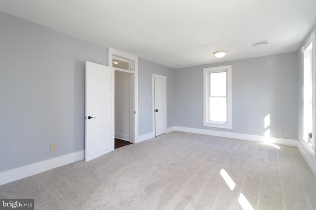 unfurnished bedroom with carpet, visible vents, and baseboards