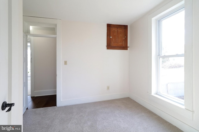 carpeted empty room with baseboards