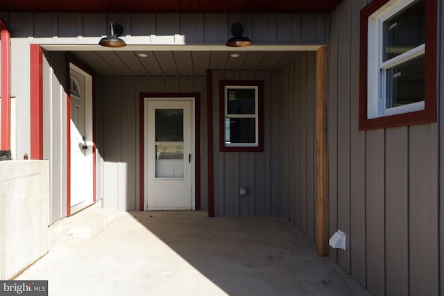 doorway to property featuring board and batten siding and a garage