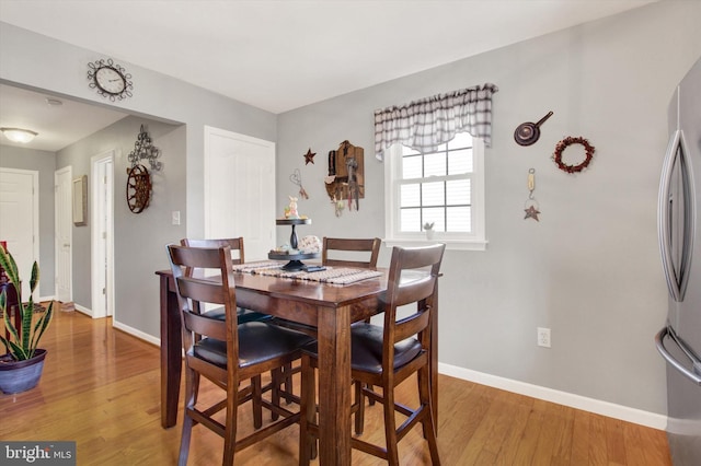 dining area featuring baseboards and light wood-style floors